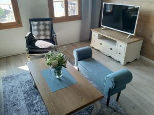 uma sala de estar com uma mesa e uma televisão em App. Seeblick Top of Interlaken em Beatenberg