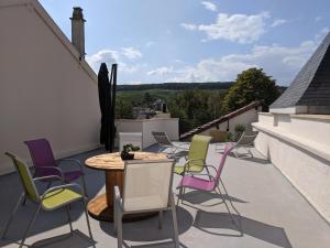 um pátio com cadeiras e uma mesa na varanda em Terrasse 86 - Terrasse & Climatisation - 4-6 personnes - BnB Epernay em Épernay