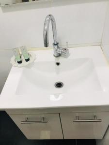 a white sink sitting under a white counter top at Ashel Hotel in Beer Sheva