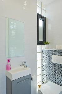 a bathroom with a sink and a toilet and a mirror at Luxury Duplex, sea view 2min to beach parking in Tel Aviv