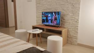 uma sala de estar com televisão num suporte de madeira em Apartment ORANGE BRIST em Pula