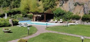 a backyard with a swimming pool with chairs and a gazebo at La Guardata Agriturismo in Montefiascone