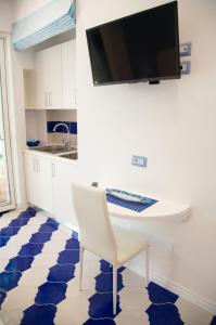 a kitchen with a table and a tv on a wall at Marilisa Holidays in Maiori
