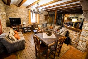 a living room with a table and a stone wall at La Mora Cantana in Castrojeriz
