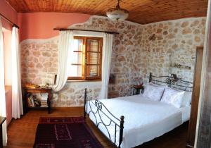 een slaapkamer met een bed in een kamer met stenen muren bij The old stone house in Paramythia