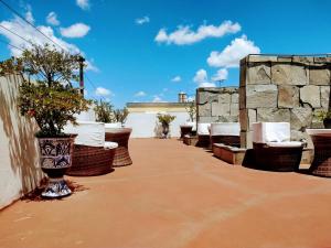 een patio met stoelen en een stenen muur bij Suites La Concordia in Puebla