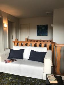 a white couch with blue pillows in a room at B&B côté jardin in Villers-Outréaux