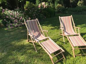 two chairs sitting in the grass in a yard at B&B côté jardin in Villers-Outréaux