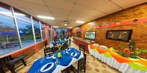 een eetkamer met tafels met blauwe en witte tafels bij Hotel Campestre Los Tucanes in Armenia