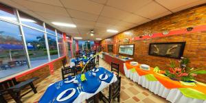 a dining room with tables with blue and white table settings at Hotel Campestre Los Tucanes in Armenia