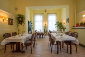 a restaurant with tables and chairs in a room at Hotel Knöpel in Wismar
