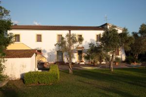 a large white building with trees in front of it at Relais Masseria Casiello in San Castrese