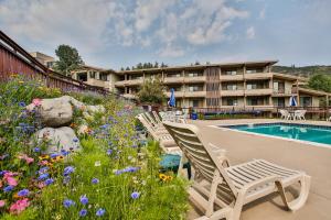 a hotel with a garden of flowers next to a swimming pool at Pokolodi Lodge in Snowmass Village