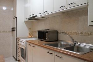 a kitchen with a sink and a microwave at Casa De La Virginia in Valdealgorfa +25 photos
