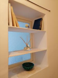 ein Regal mit Büchern und einer Schüssel darauf in der Unterkunft La Blu in Capracotta