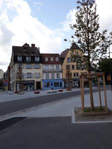 a city street with buildings and a tree in the middle at Le Quai 2 in Strasbourg