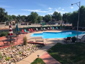a swimming pool with chairs and umbrellas in a yard at Rainbow Lodge and Inn in Colorado Springs