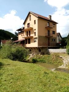 a house on a hill next to a river at Guesthouse Smiljanić in Slavkovica