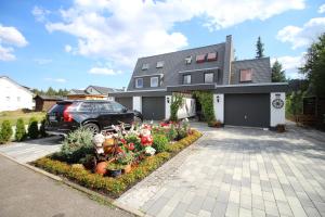 une maison avec une voiture garée dans l'allée dans l'établissement Ferienhaus Frei 2 Titisee, à Titisee-Neustadt