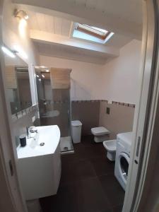a bathroom with a sink and a toilet and a mirror at Una piccola casa al mare in San Domino