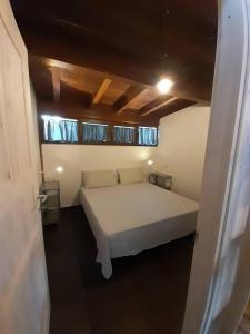 a bedroom with a white bed with two windows at Una piccola casa al mare in San Domino