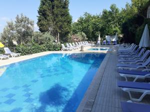 a large swimming pool with chairs and umbrellas at Atamer Doga Resort in Gemlik