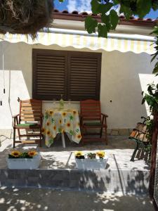 eine Terrasse mit 2 Stühlen und einem Tisch mit Blumen in der Unterkunft Apartman Manuela in Matulji