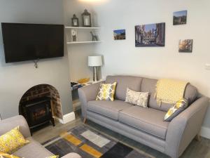 a living room with a couch and a fireplace at Archie's Cottage in Lincoln