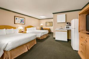 a hotel room with two beds and a kitchen at Travelodge by Wyndham Dawson Creek in Dawson Creek