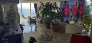 a living room with potted plants on the floor at Atamer Doga Resort in Gemlik