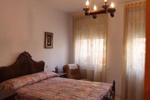 a bedroom with a bed and a chair and a window at Casa De La Virginia in Valdealgorfa