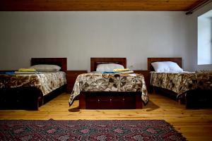 a room with two beds and a rug at Guesthouse Shtini in Fshat