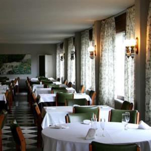 a dining room with white tables and green chairs at El Pradet in El Serrat