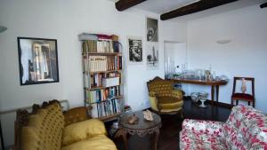 a living room with a couch and a book shelf with books at Locanda degli Sfizi in Cravanzana