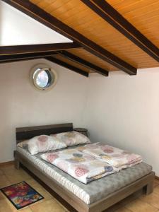 a bed in a room with a wooden ceiling at Ubytovanie v hosťovskom dome Flower in Veľký Meder