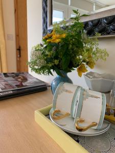 stół z wazą z talerzem i kwiatami w obiekcie Clones 'Greenjoy - B&B w mieście Corconnelly