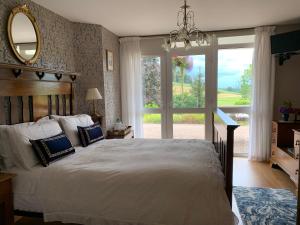 a bedroom with a large bed and a large window at Clones 'Greenjoy - B&B in Corconnelly