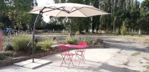 un tavolo e sedie rosse sotto un ombrellone di au fabuleux festin a La Possonnière