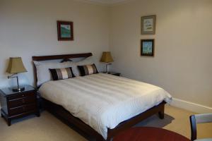 a bedroom with a bed and two lamps on tables at Hatsue Guest House in Camberley