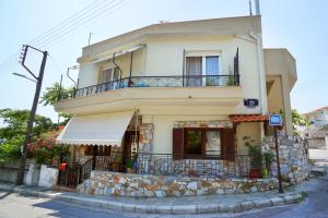 una grande casa bianca con balcone su una strada di Katerina's apartment a Kavala