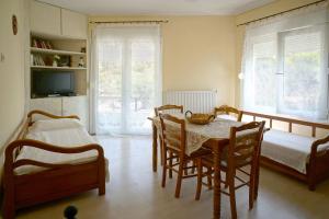 una sala da pranzo con tavolo, sedie e letto di Katerina's apartment a Kavala