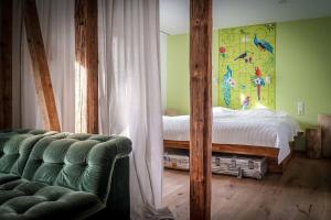 een slaapkamer met een bed en een bank in een kamer bij Besighomes Apartment Olive in Besigheim