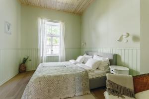 ein grünes Schlafzimmer mit einem Bett und einem Fenster in der Unterkunft Villa Frieda in Haapsalu