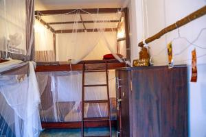 a room with a bunk bed and a ladder at Chez Podi Surf Stay in Mirissa