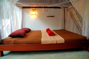 a bed with two pillows on it in a bedroom at Chez Podi Surf Stay in Mirissa