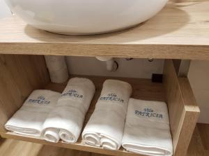 una mensola con quattro asciugamani laminati in bagno di Villa Patricia a Stari Grad (Cittavecchia)