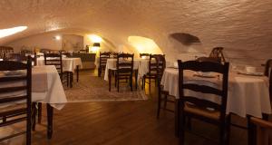 a restaurant with white tables and chairs in a tunnel at Hotel Boterhuis in Bruges