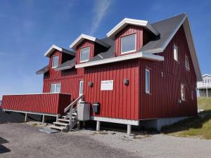 ein rotes Haus mit schwarzem Dach in der Unterkunft Eagle View in Nuuk