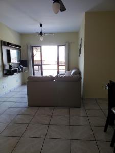 ein Wohnzimmer mit einem Sofa und einem großen Fenster in der Unterkunft ÓTIMO APTO PERTO DA PRAIA in Cabo Frio