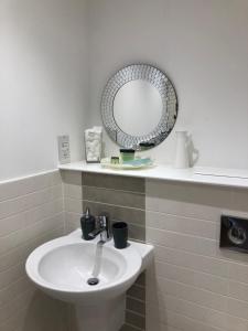 a bathroom with a white sink and a mirror at Hansen House 2 with Private Parking in Cardiff +9 photos
